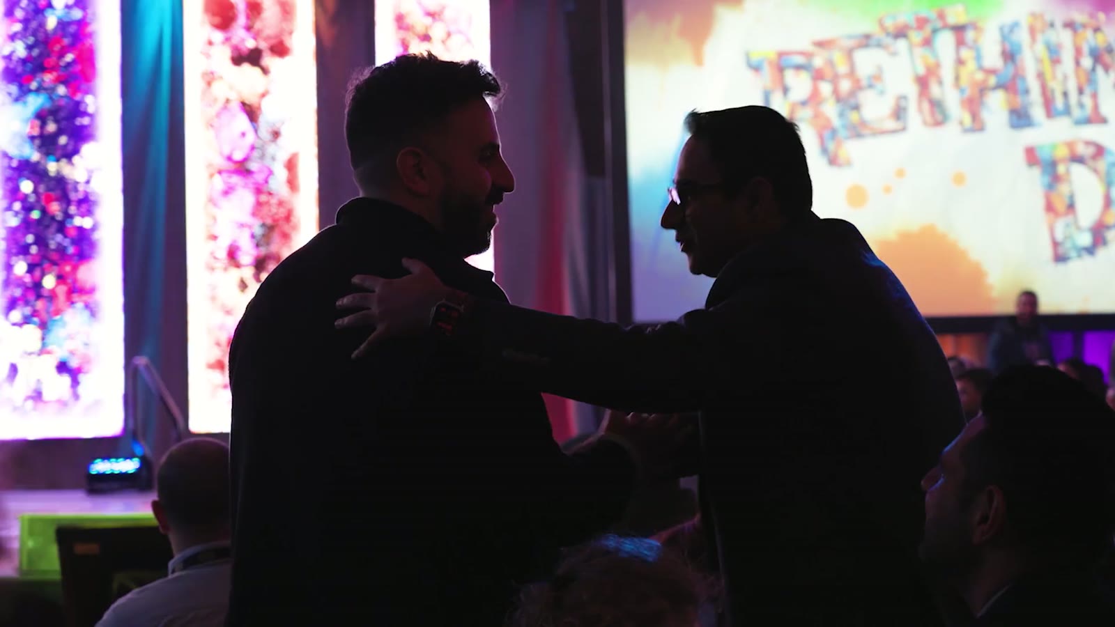 [CONFIRM] Guests greeting each other at an evening reception.