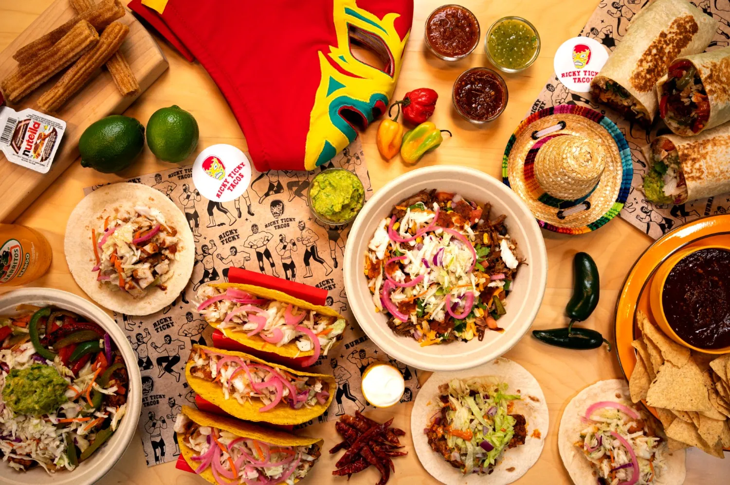 Three loaded tacos in a tray with a drink beside them.